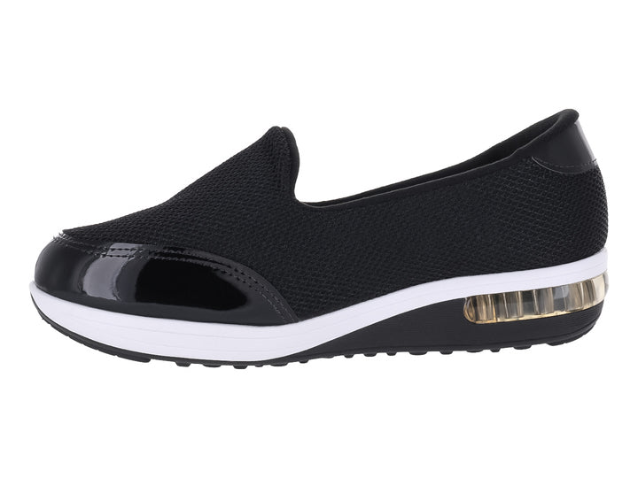 Zapato plano Modare negro de tela con detalles en charol y suela blanca con amortiguador transparente.