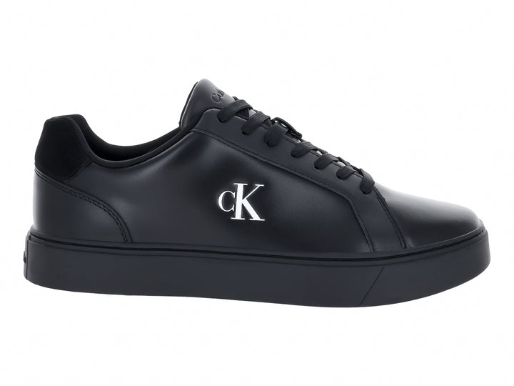 Tenis casuales Calvin Klein de cuero negro con logotipo blanco en el lateral y suela plana negra.