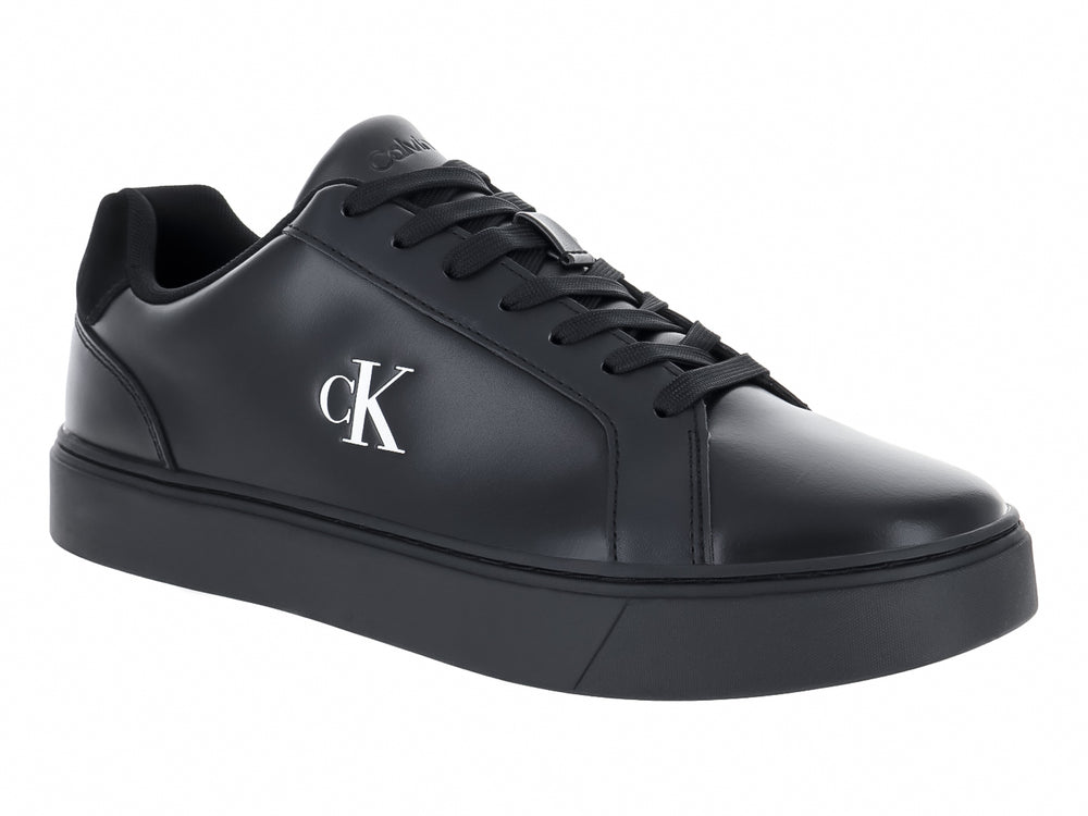 Tenis casuales Calvin Klein de cuero negro con logotipo blanco en el lateral y suela plana negra.