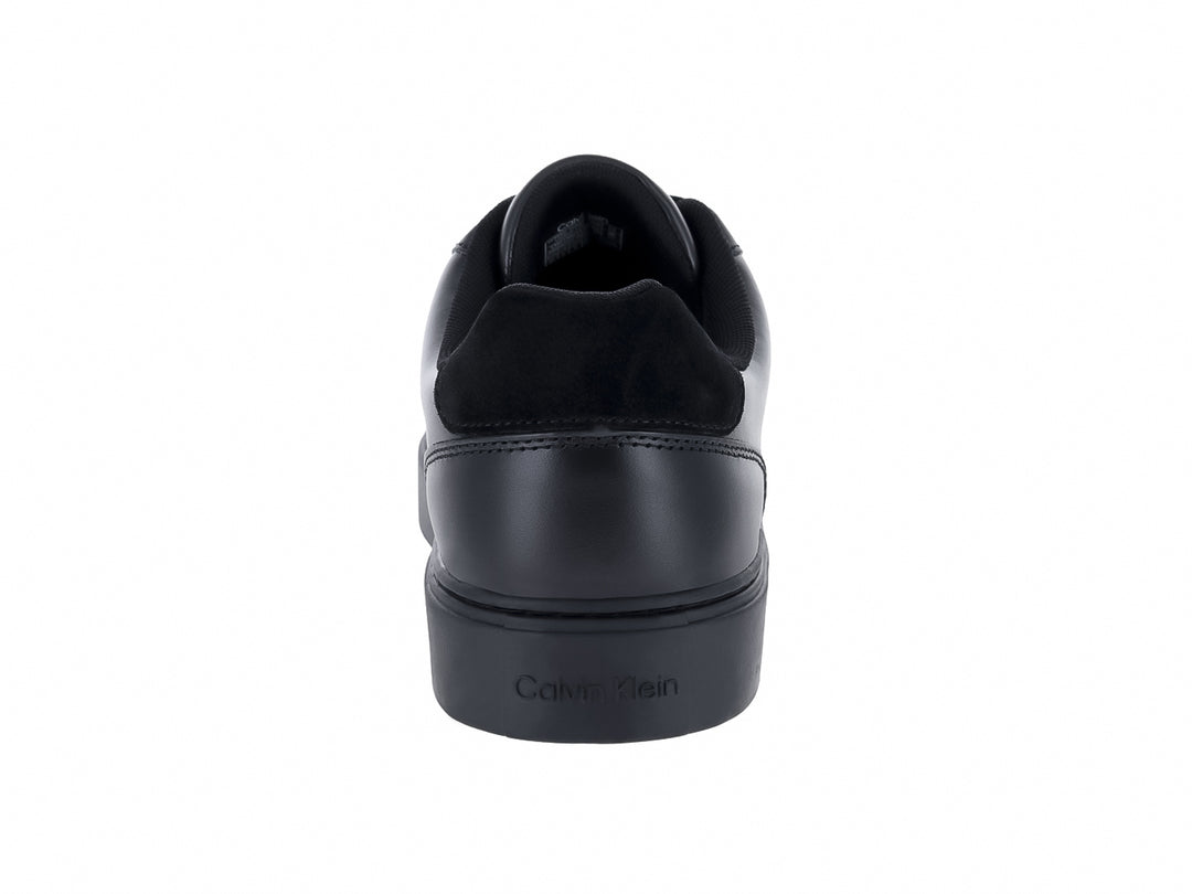 Tenis casuales Calvin Klein de cuero negro con logotipo blanco en el lateral y suela plana negra.
