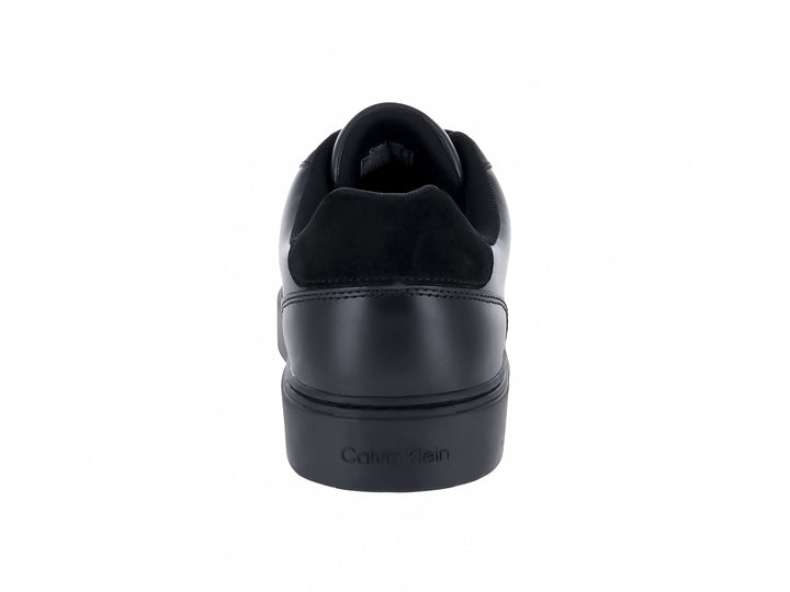 Tenis casuales Calvin Klein de cuero negro con logotipo blanco en el lateral y suela plana negra.