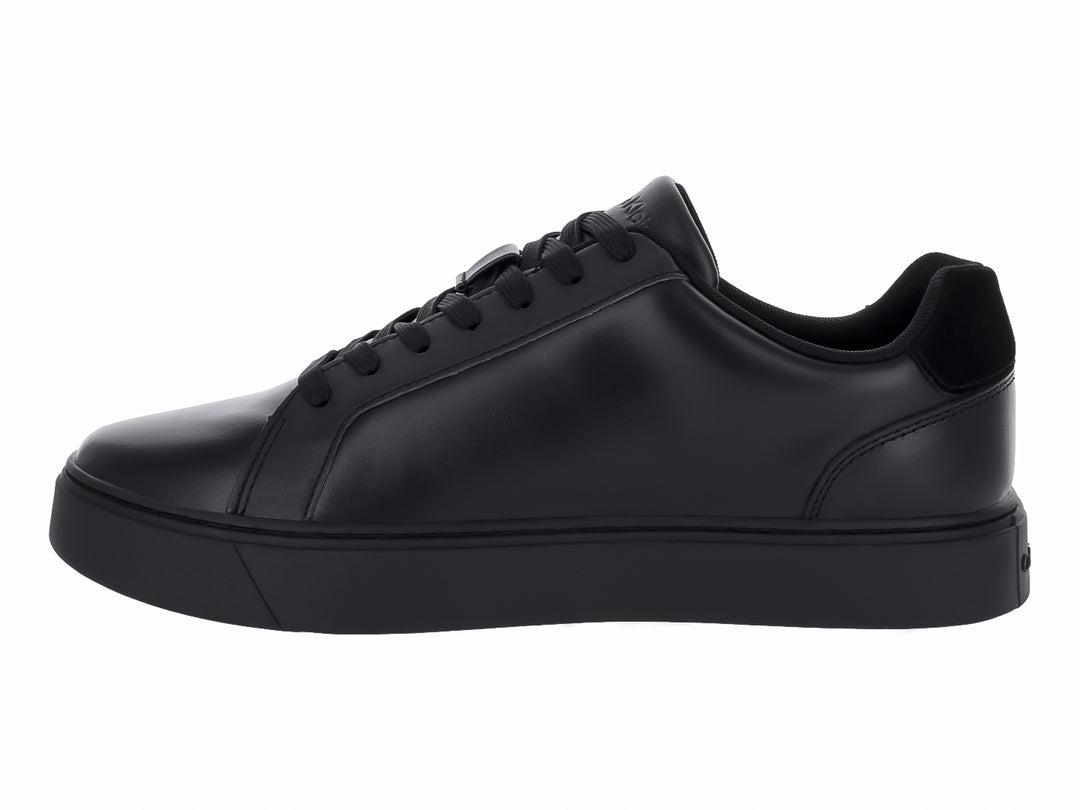 Tenis casuales Calvin Klein de cuero negro con logotipo blanco en el lateral y suela plana negra.