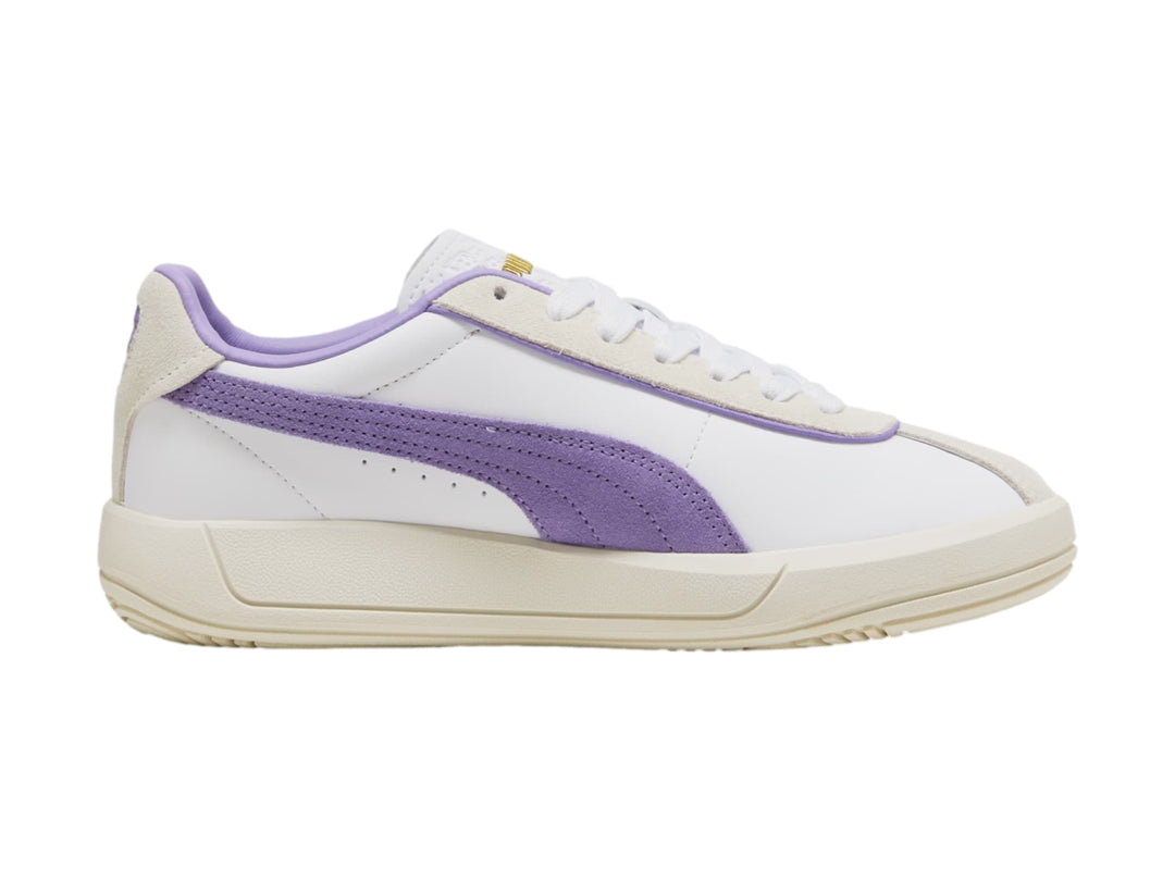 Tenis PUMA blancos con detalle lateral en color lavanda y suela en tono blanco cálido.