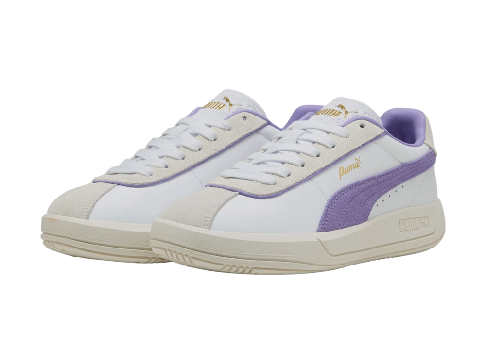 Tenis PUMA blancos con detalle lateral en color lavanda y suela en tono blanco cálido.