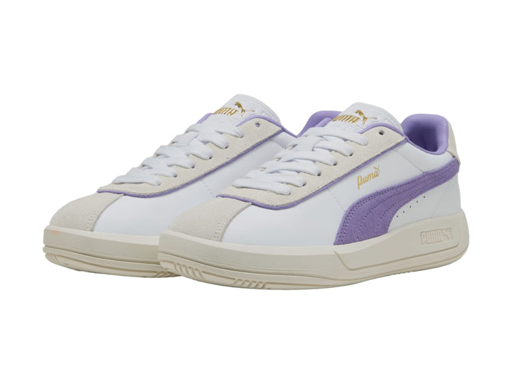 Tenis PUMA blancos con detalle lateral en color lavanda y suela en tono blanco cálido.