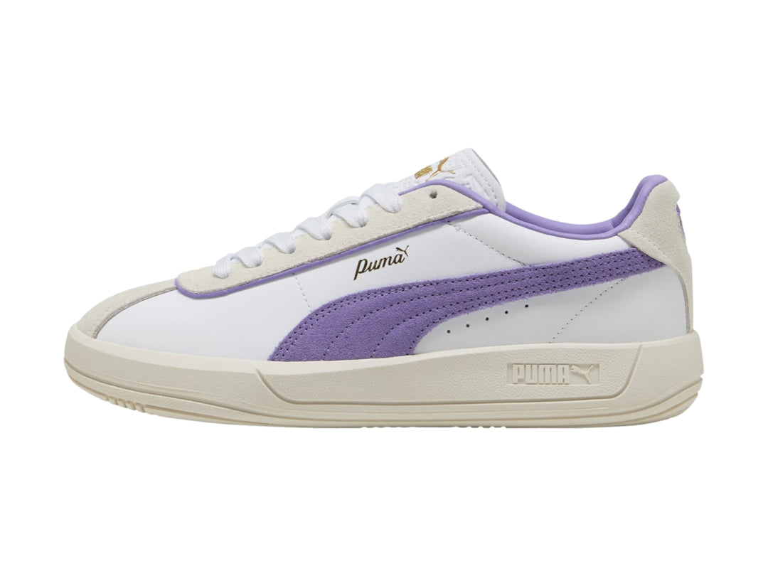 Tenis PUMA blancos con detalle lateral en color lavanda y suela en tono blanco cálido.
