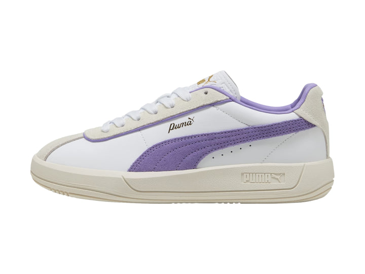 Tenis PUMA blancos con detalle lateral en color lavanda y suela en tono blanco cálido.