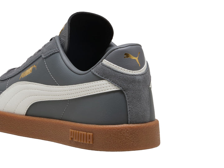 Tenis PUMA Club II Era en color gris oscuro con franja blanca y suela de goma color café.