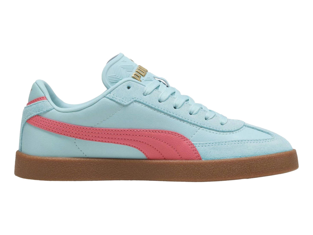 Tenis PUMA color azul claro con franja rosa y suela de goma marrón.