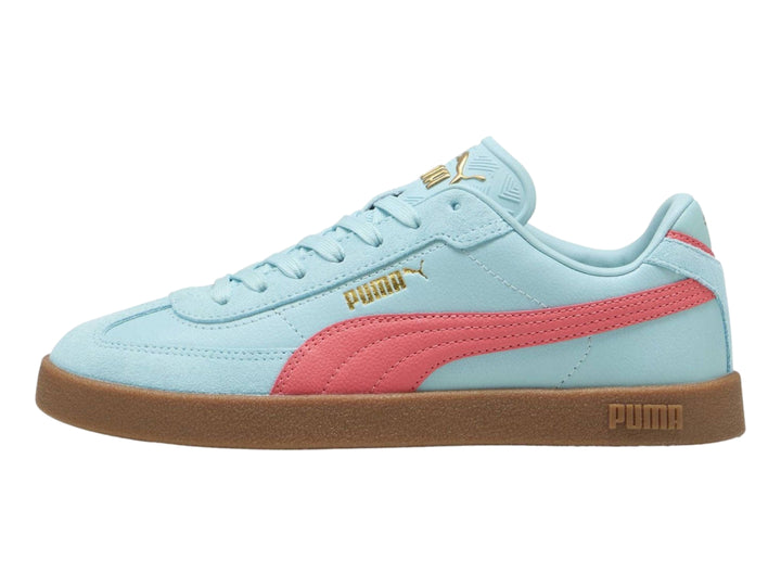 Tenis PUMA color azul claro con franja rosa y suela de goma marrón.