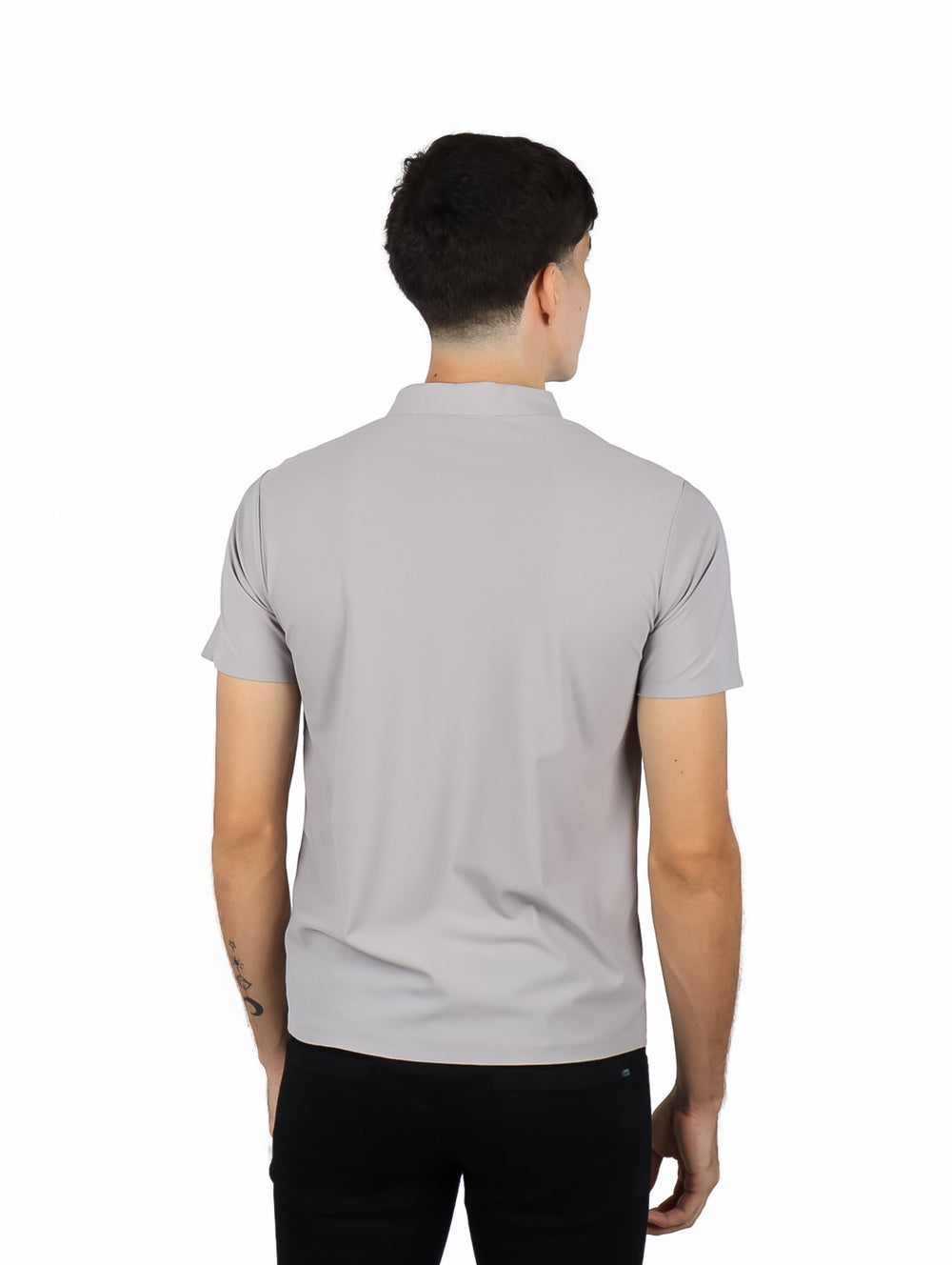 Hombre vistiendo una playera polo de color gris con cuello y manga corta.