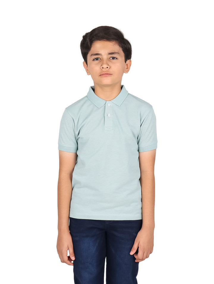Niño vistiendo una playera polo de color azul claro y pantalones azul marino.