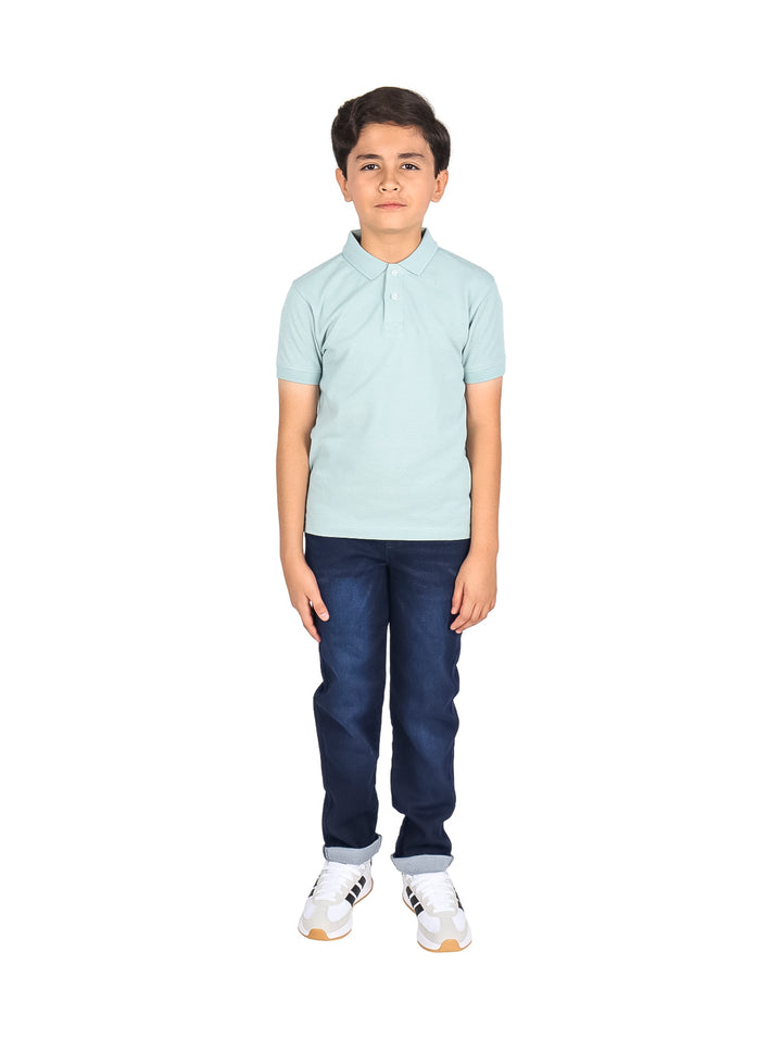 Niño vistiendo una playera polo de color azul claro y pantalones azul marino.