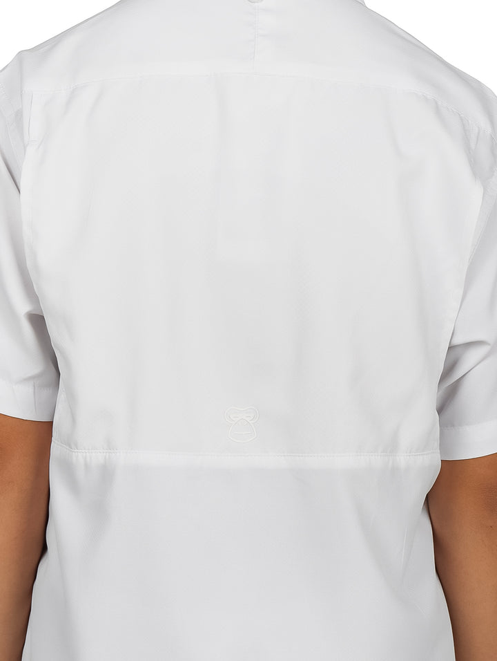 Ni�o modelando una camisa blanca de manga corta con bolsillos y pantalones cargo color verde oliva.