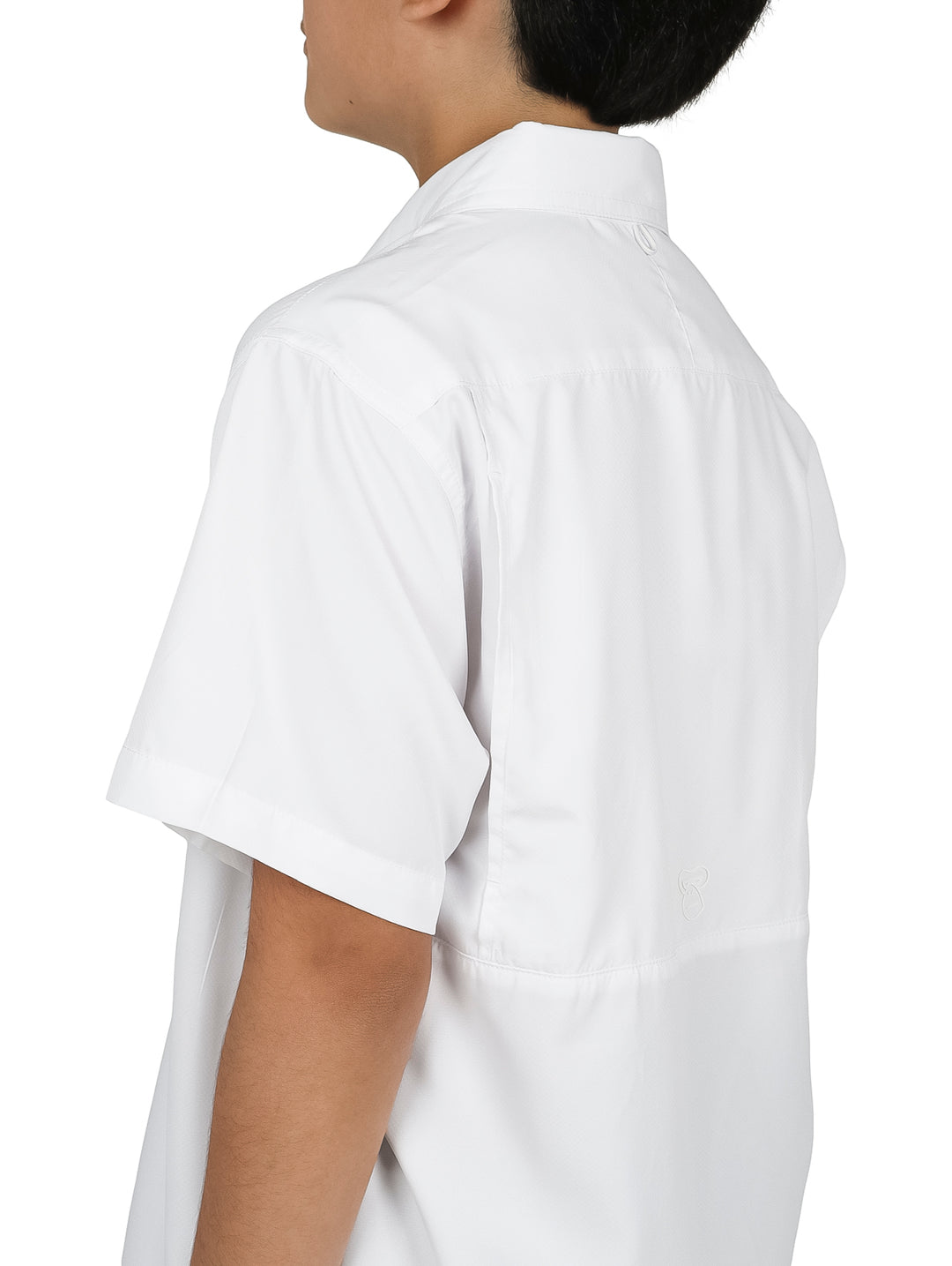 Ni�o modelando una camisa blanca de manga corta con bolsillos y pantalones cargo color verde oliva.