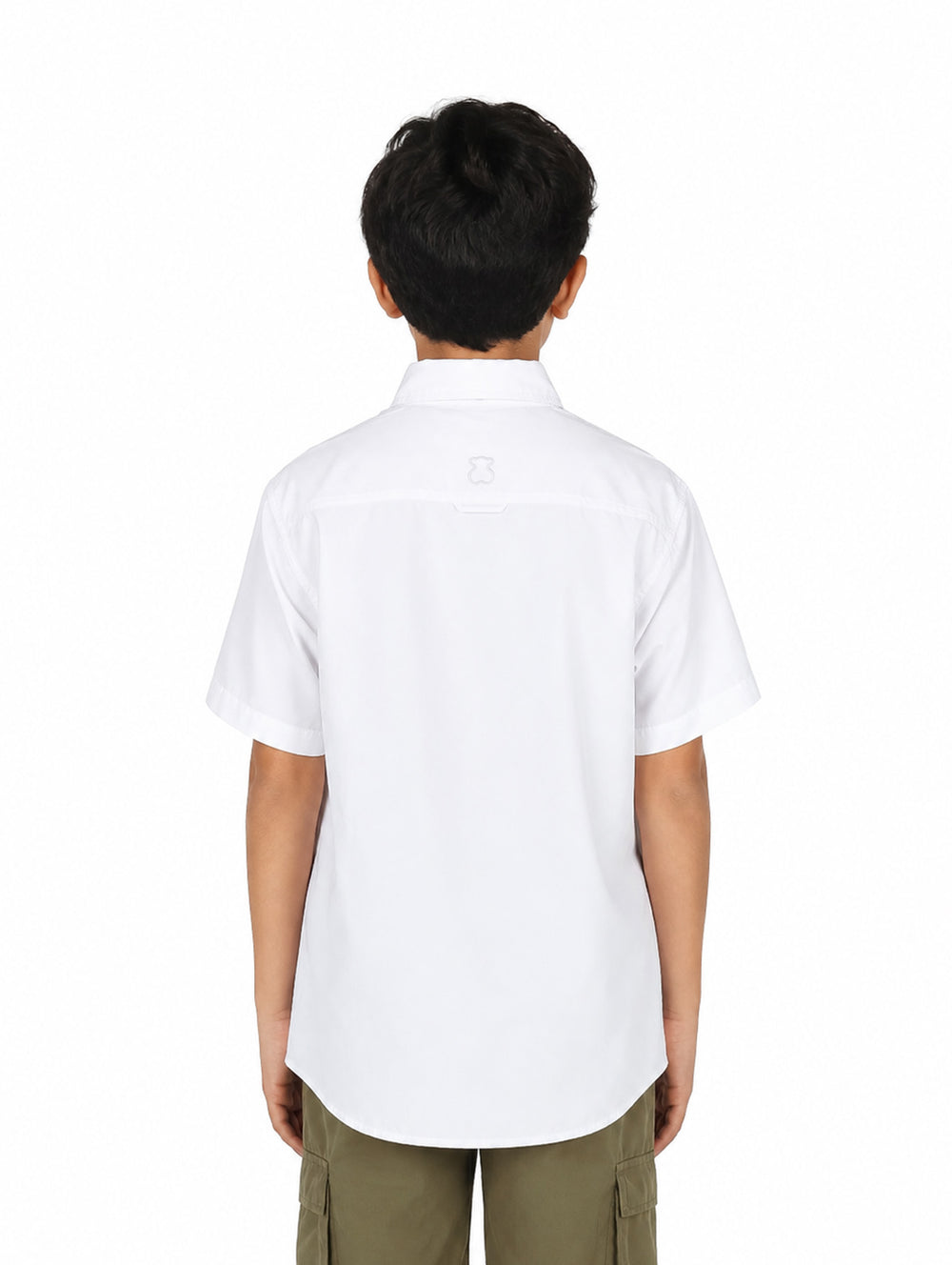 Niño vistiendo una camisa outdoor de color blanco con manga corta y dos bolsillos frontales.