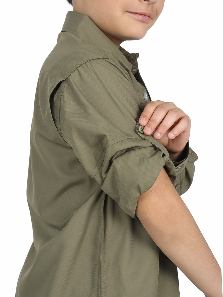 Niño vistiendo camisa de manga larga color verde militar y pantalones beige sobre fondo blanco.