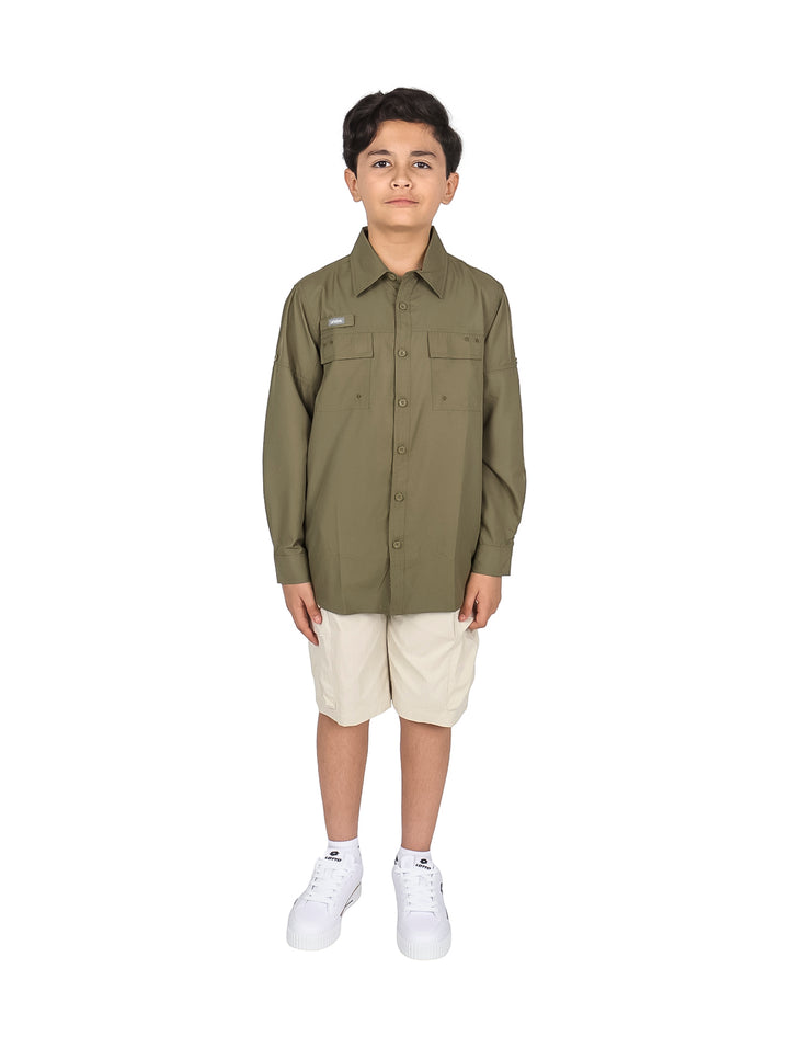 Niño vistiendo camisa de manga larga color verde militar y pantalones beige sobre fondo blanco.