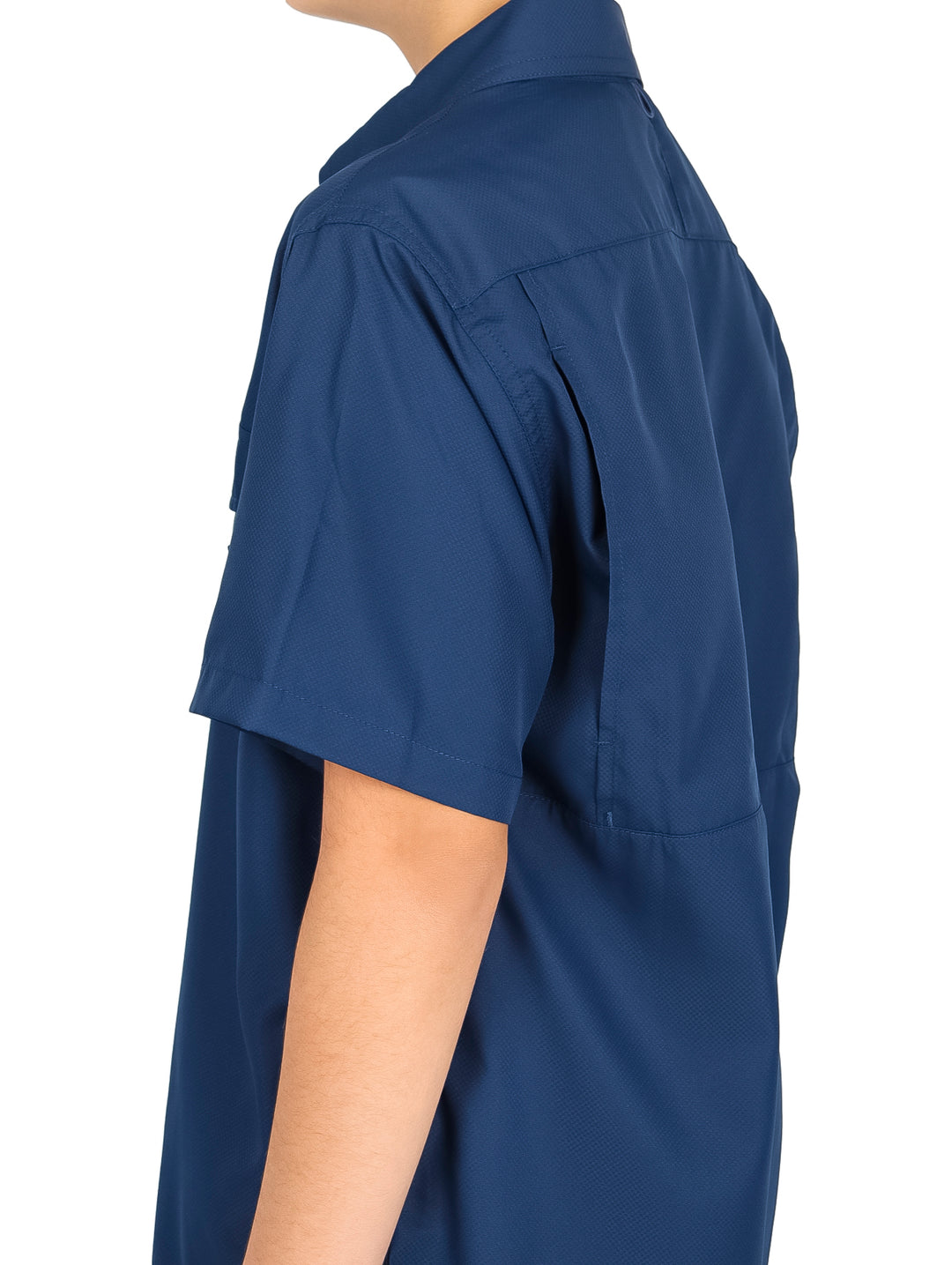 Niño vistiendo una camisa casual color navy de manga corta con bolsillos frontales y pantalones negros.