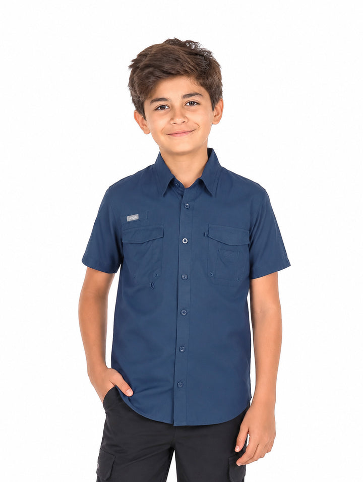 Niño vistiendo una camisa outdoor de manga corta en color azul marino con bolsillos frontales y cuello.