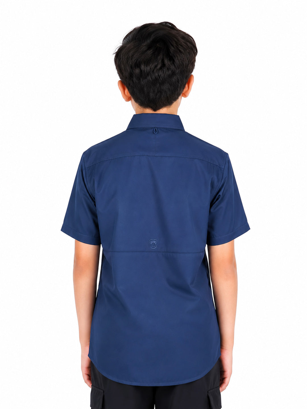 Niño vistiendo una camisa outdoor de manga corta en color azul marino con bolsillos frontales y cuello.