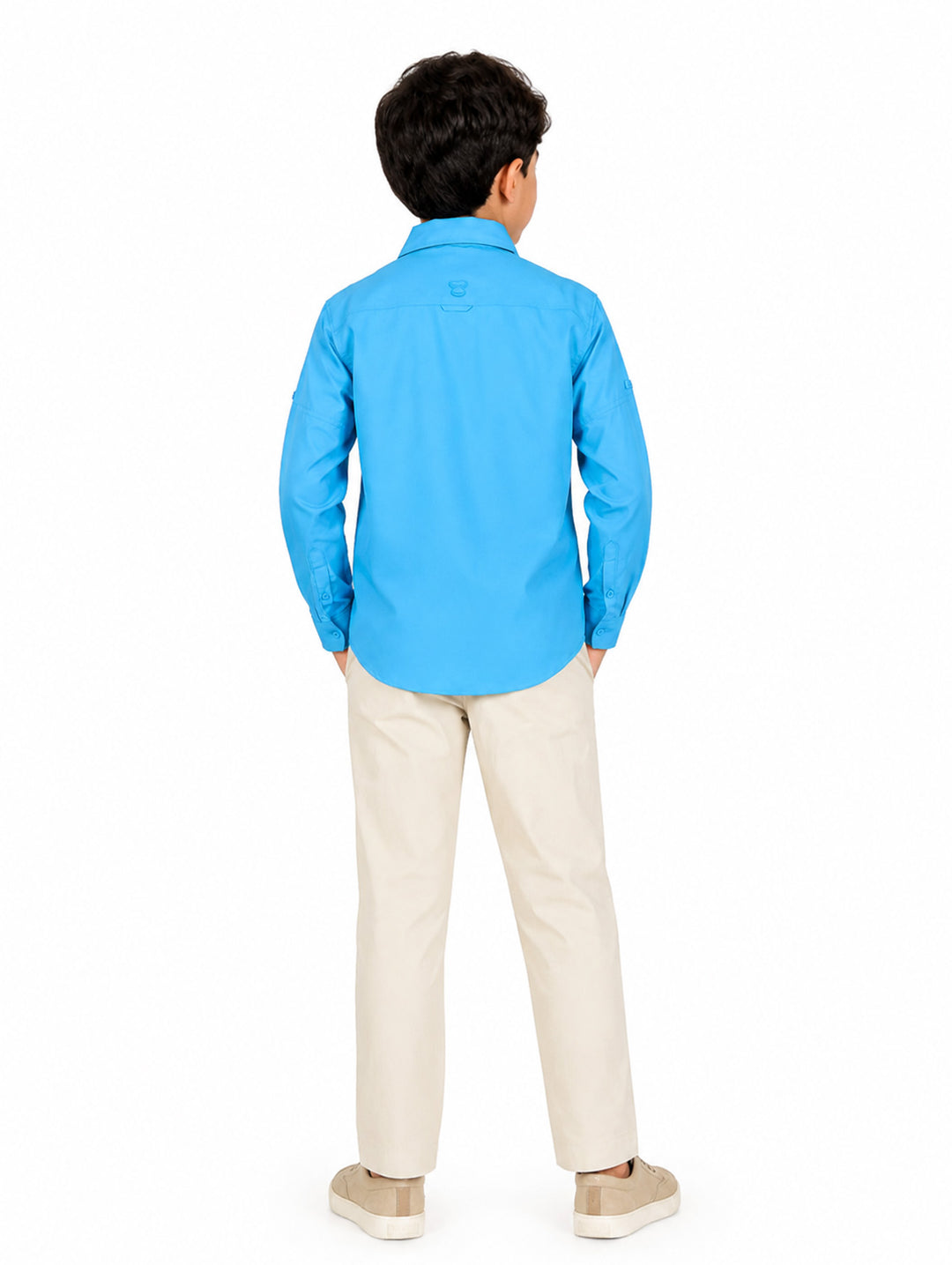 Niño vistiendo una camisa outdoor de color azul echo blue con manga larga y bolsillos frontales.