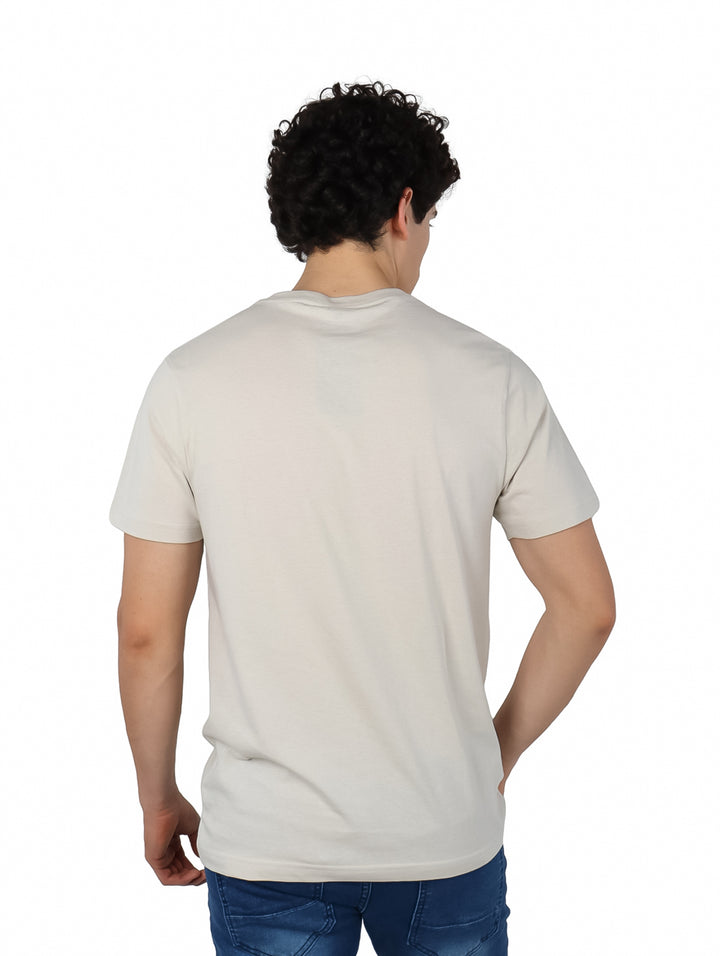 Hombre vistiendo una camiseta Hurley de color hueso con logotipo bordado en el pecho y manga corta.