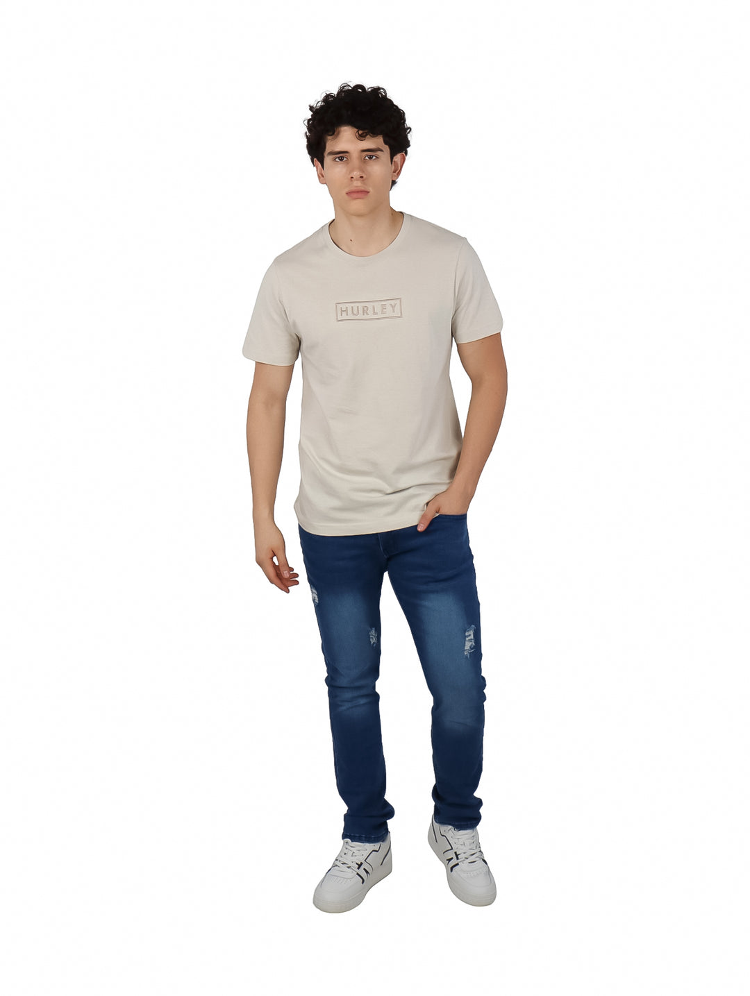 Hombre vistiendo una camiseta Hurley de color hueso con logotipo bordado en el pecho y manga corta.