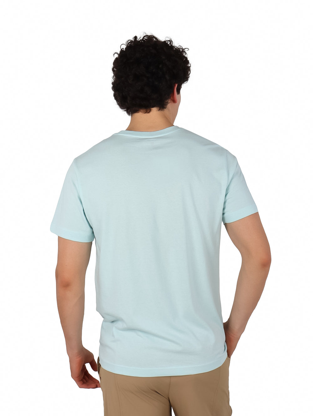 Hombre usando playera Hurley de color teal tinted y pantalones beige.