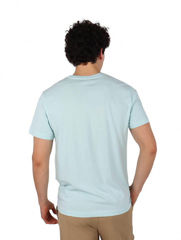 Hombre usando playera Hurley de color teal tinted y pantalones beige.
