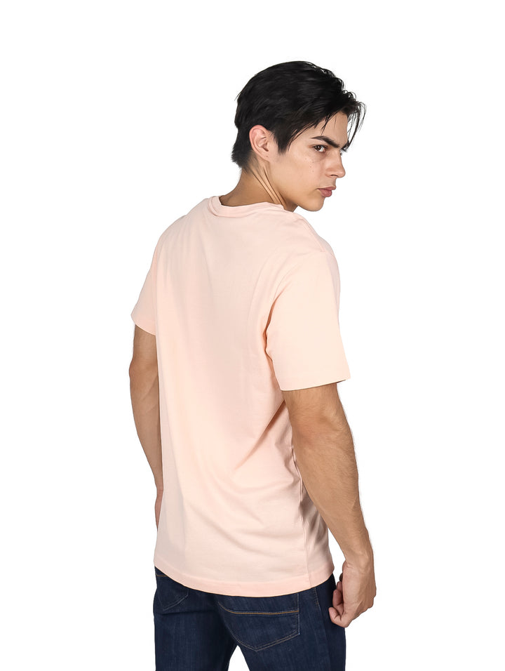 Hombre usando camiseta de manga corta color rosa claro con logo frontal de Hurley.