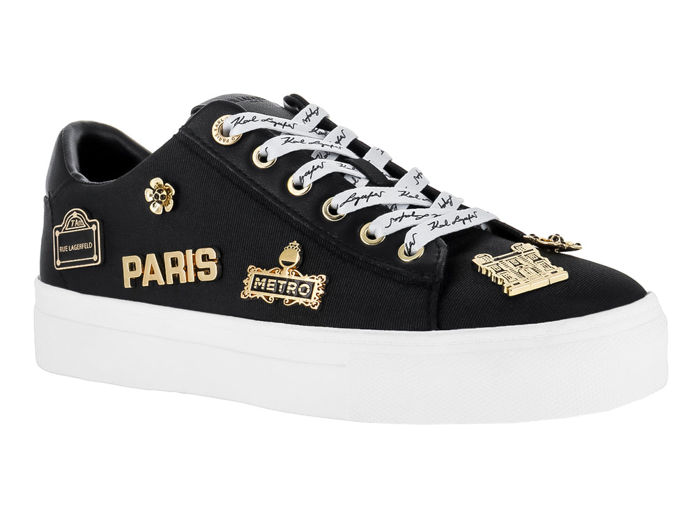 Tenis negros Karl Lagerfeld con suela blanca y pines decorativos dorados con texto Paris y Metro.
