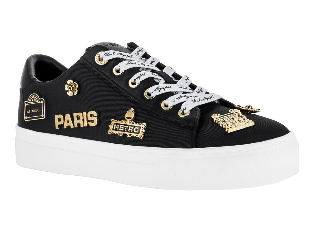 Tenis negros Karl Lagerfeld con suela blanca y pines decorativos dorados con texto Paris y Metro.