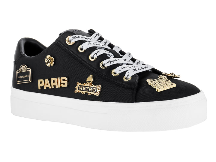 Tenis negros Karl Lagerfeld con suela blanca y pines decorativos dorados con texto Paris y Metro.