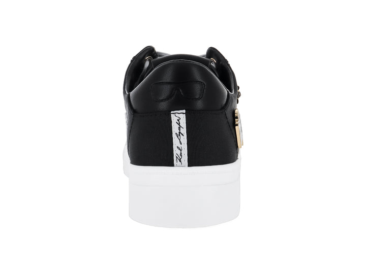 Tenis negros Karl Lagerfeld con suela blanca y pines decorativos dorados con texto Paris y Metro.