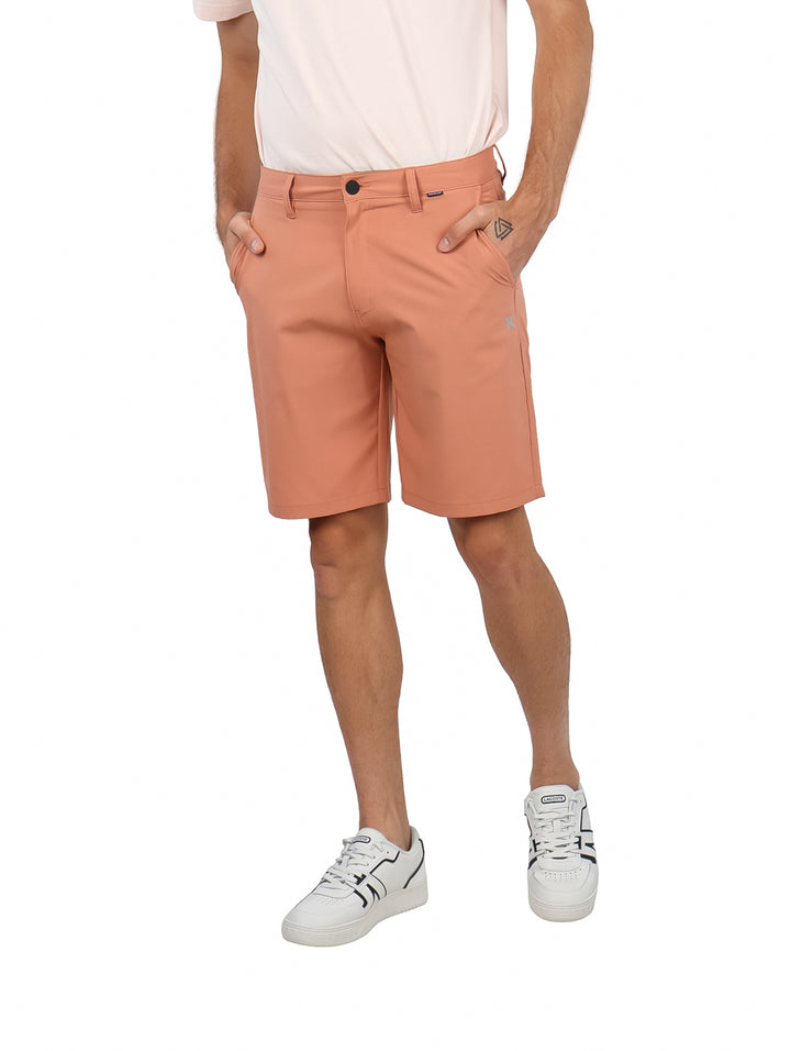 Hombre vistiendo shorts Hurley color Martian Rust, estilo híbrido para surf y caminata.