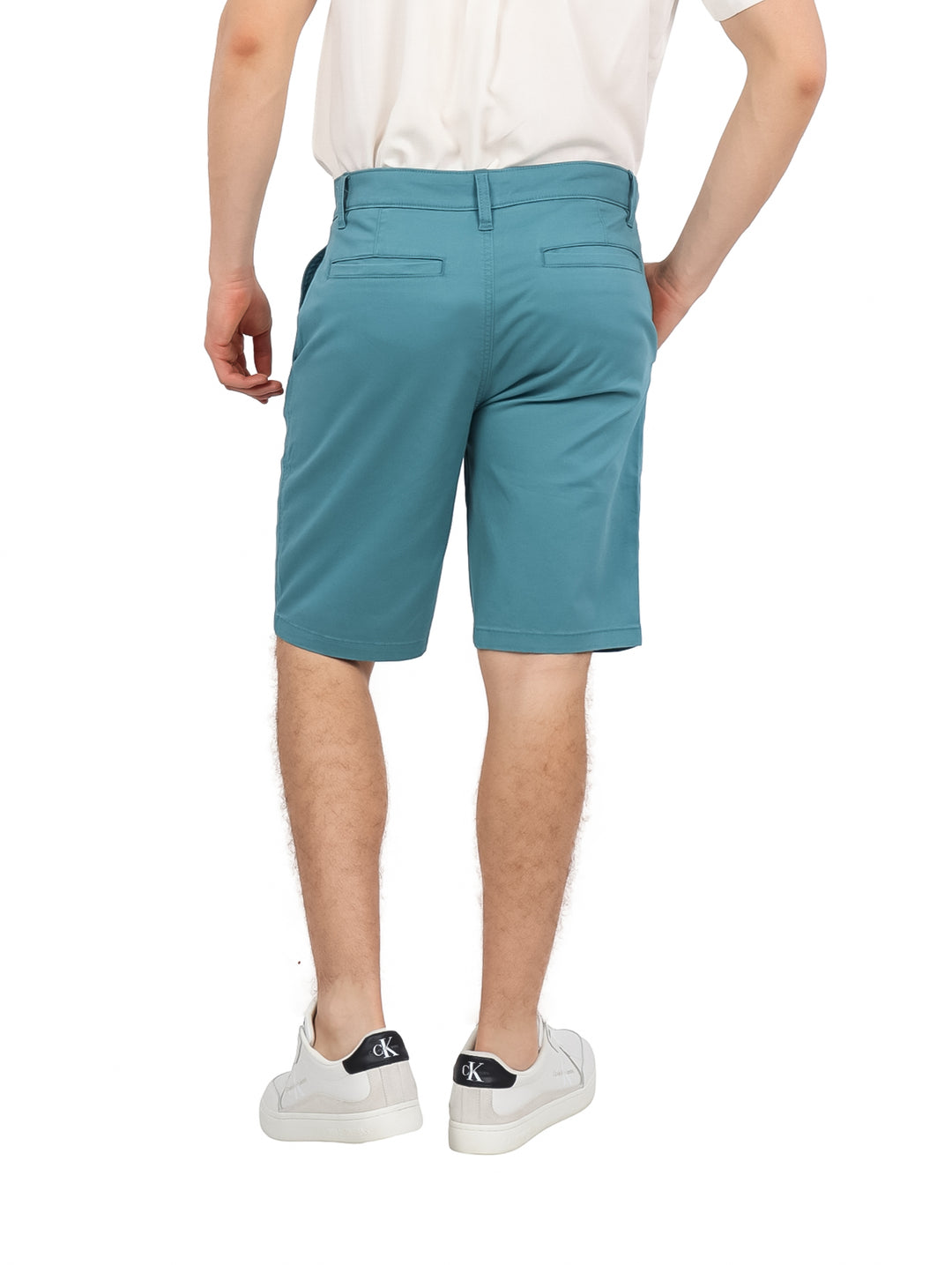 Hombre vistiendo pantalones cortos Hurley color Deep Emerald de corte clásico y textura mate.