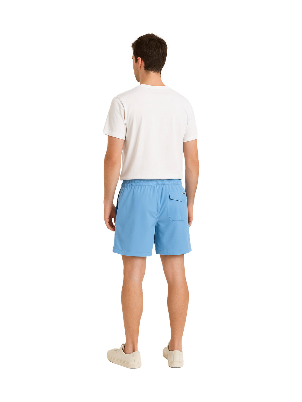 Hombre vistiendo shorts de natación Hurley color azul claro con camiseta blanca y tenis blancos.