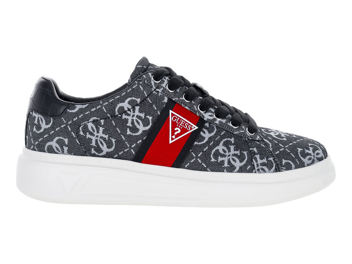 Tenis Guess gris y negro con estampado de monograma, detalle en rojo y suela blanca.