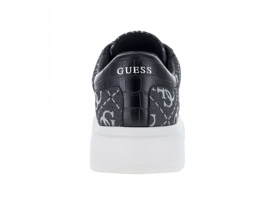 Tenis Guess gris y negro con estampado de monograma, detalle en rojo y suela blanca.