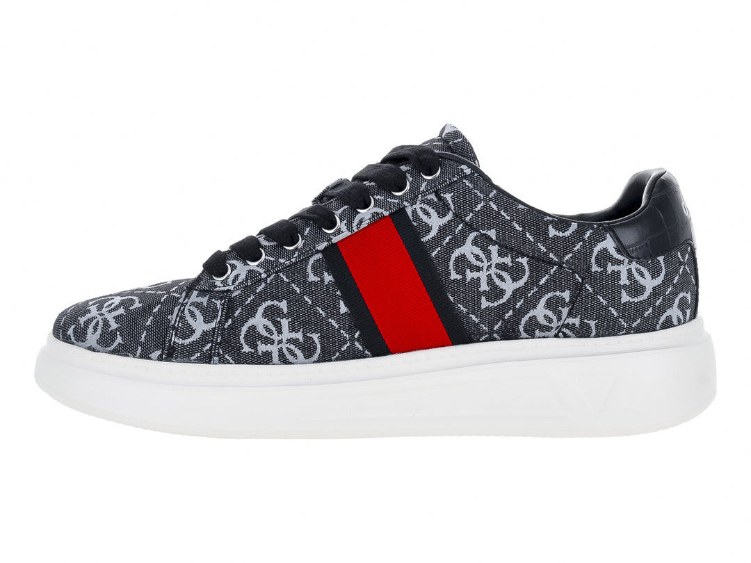 Tenis Guess gris y negro con estampado de monograma, detalle en rojo y suela blanca.