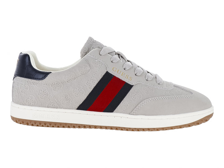 Tenis Guess color natural con franjas azul y rojo en el lateral, suela blanca y detalles en azul marino.