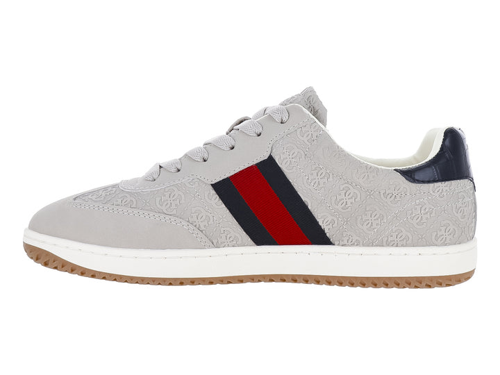 Tenis Guess color natural con franjas azul y rojo en el lateral, suela blanca y detalles en azul marino.