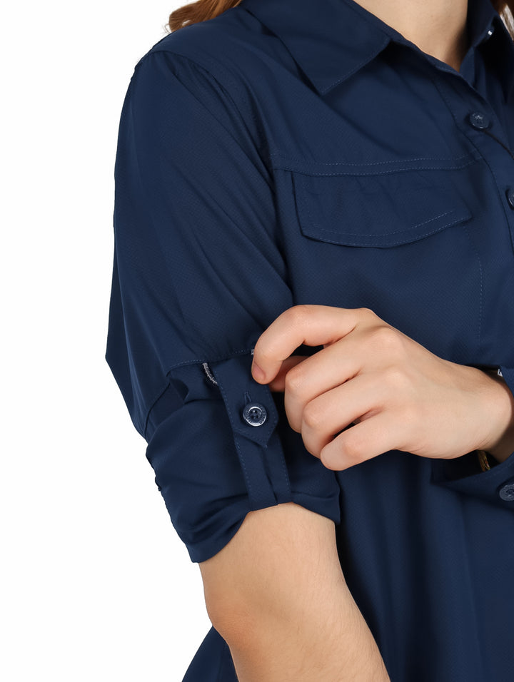 Mujer vistiendo una camisa UNGA de manga larga en color azul navy con bolsillos frontales y estilo outdoor.