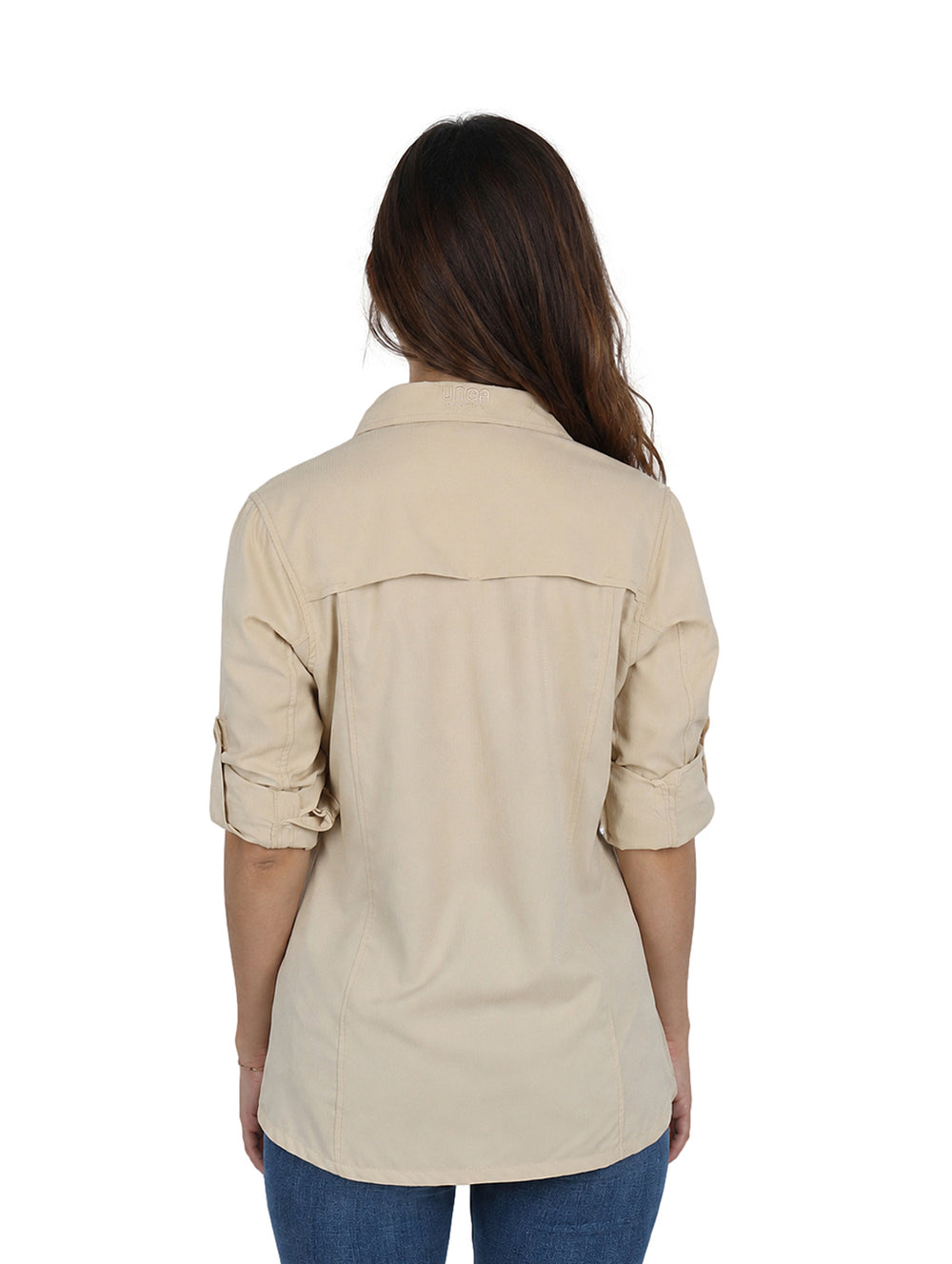 Mujer vistiendo una camisa de manga larga color beige estilo outdoor con botones y bolsillos delanteros.
