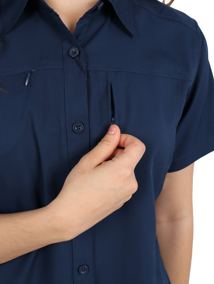 Mujer vistiendo una camisa outdoor de color azul marino con manga corta y cuello.
