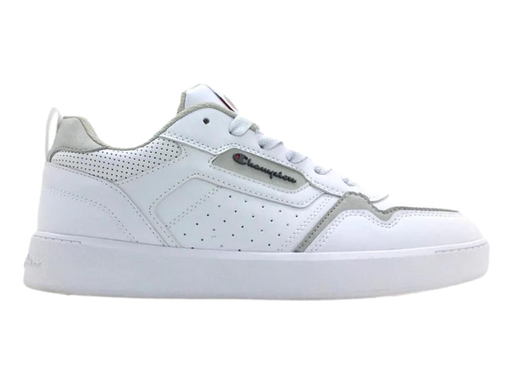 Tenis Champion color blanco con detalles en gris y perforaciones laterales, vista lateral.
