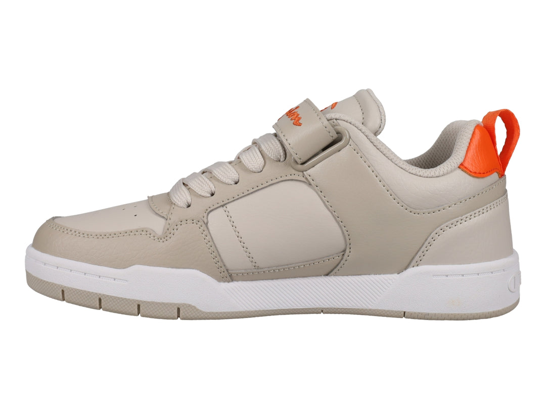 Tenis Champion color beige con detalles en naranja, suela blanca y cierre de agujetas con correa de velcro.