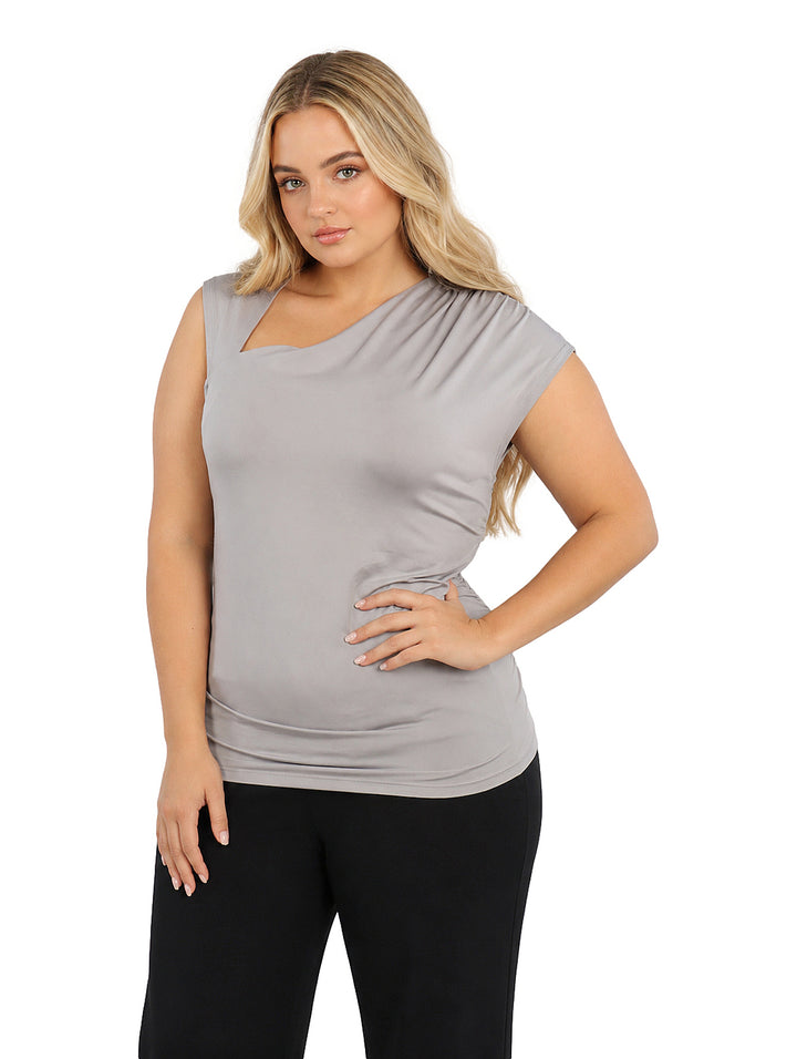 Mujer vistiendo blusa color gris con cuello asimétrico y corte sin mangas.