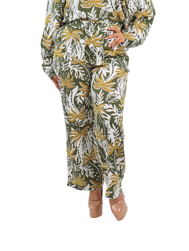 Pantalón ancho con estampado de hojas tropicales en colores verde, blanco y amarillo.